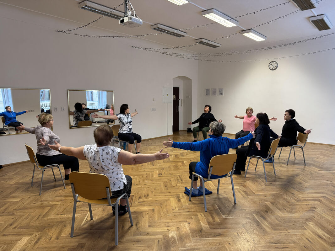 senioři cvičící na židlích