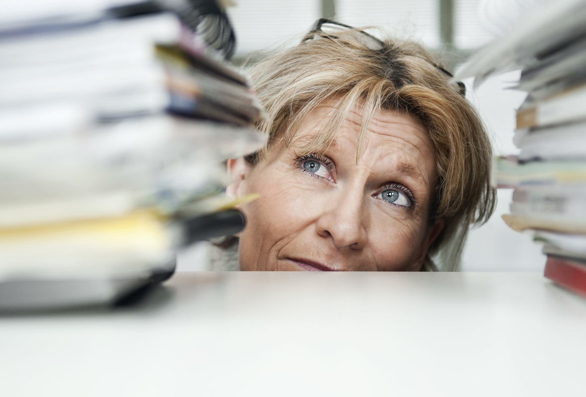 žena dívající se nejistě na stoh formulářů před sebou