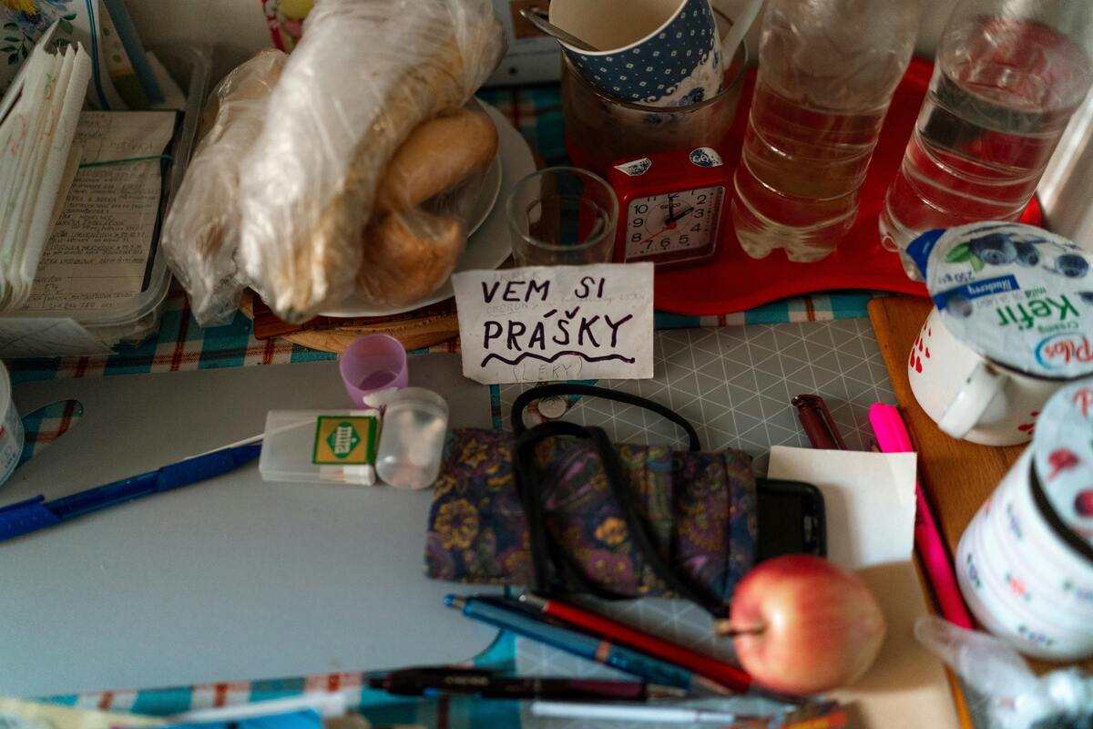 léky v dávkovači položené na stolce s ručně psanou cedulkou "Vem si přášky"