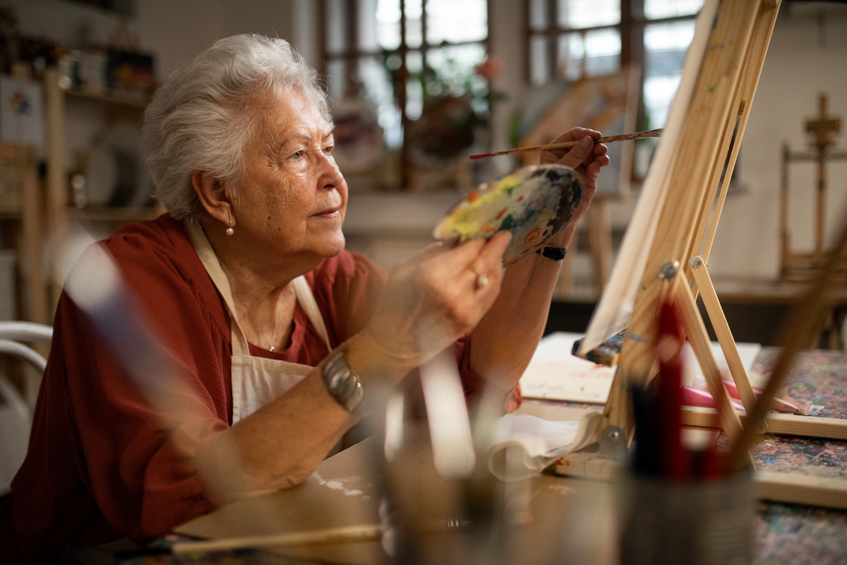 starší žena maluje na plátno