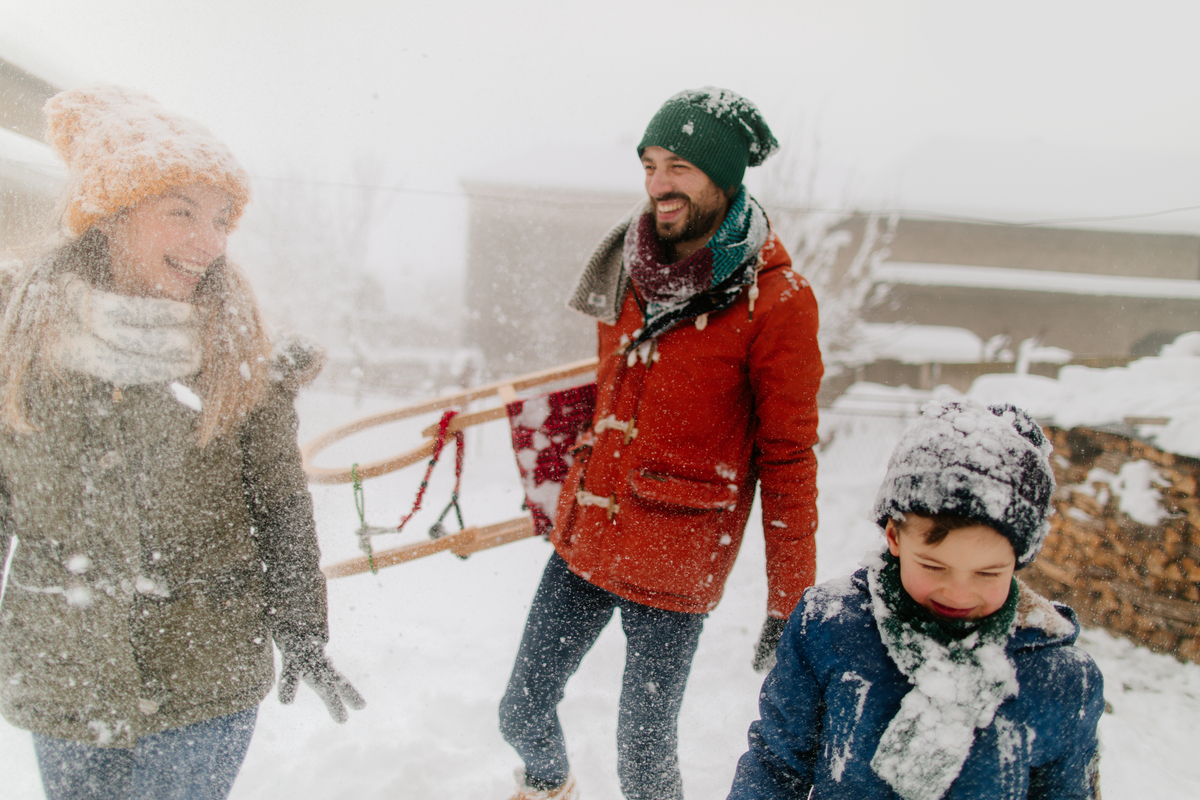 tříčlenná rodina jde společně sáňkovat