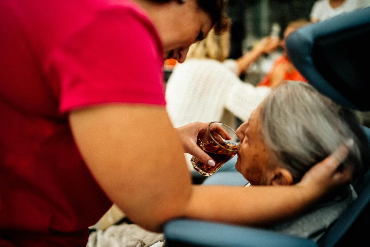 pečovatelka dává napít seniorce v odlehčovacím zařízení